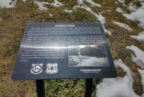 Sign about Miner's Cabin at Red Mains Mine, detailing its history and nearby activities in Medicine Bow National Forest.