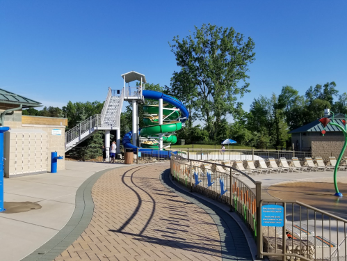 A water park featuring colorful slides, a pool area, and lounge chairs under a clear blue sky.