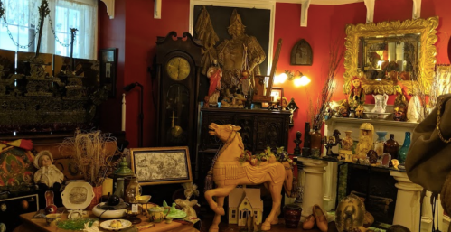 A cozy room filled with eclectic antiques, including a wooden horse, vintage decor, and various collectibles on display.