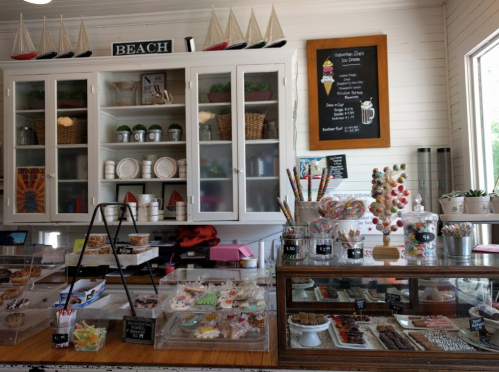 A cozy dessert shop display with various sweets, pastries, and a beach-themed decor.