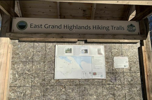 Sign for East Grand Highlands Hiking Trails featuring a map and trail information.