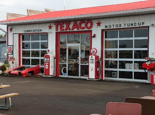 Vintage Texaco gas station with red accents, classic pumps, and a motor tune-up sign.
