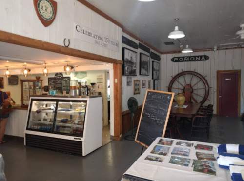 Interior of a historic building featuring a café area, display cases, and vintage decor celebrating 150 years.