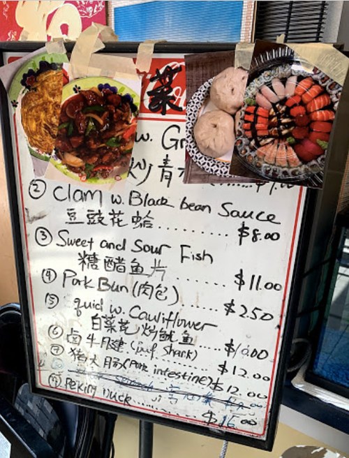 Menu board featuring various dishes, including seafood, dumplings, and sushi, with photos of food items attached.
