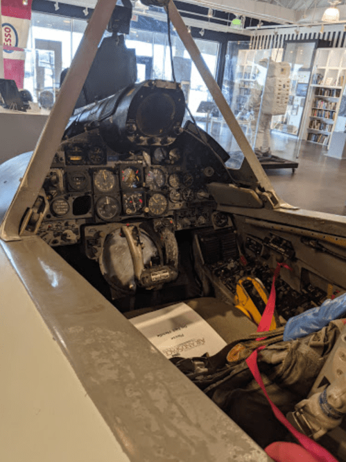 Cockpit view of an aircraft, showcasing various instruments and controls inside a museum exhibit.