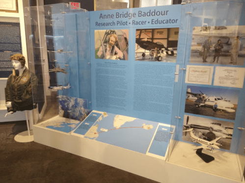 Exhibit showcasing Anne Bridge Baddour's achievements as a research pilot, racer, and educator, with artifacts and information.
