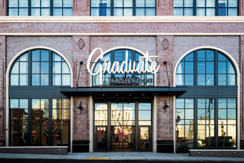 Exterior of the Graduate Nashville hotel, featuring large windows and a stylish sign.