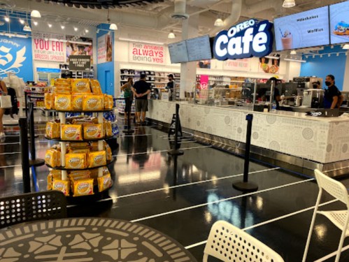Interior of an Oreo Café featuring a snack display, counter, and customers enjoying treats in a bright, modern space.
