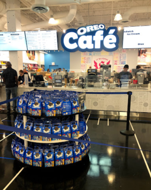 A display of Oreo products in front of the Oreo Café, featuring a menu board and customers in the background.
