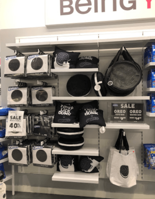 Display of Oreo-themed merchandise, including pillows, bags, and promotional signs, on a retail shelf.