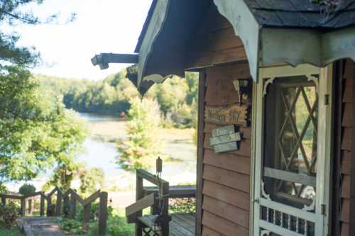 A cozy wooden cabin by a serene lake, surrounded by trees and greenery.