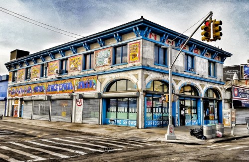 Colorful vintage building with large windows and decorative signage, located at a street corner.