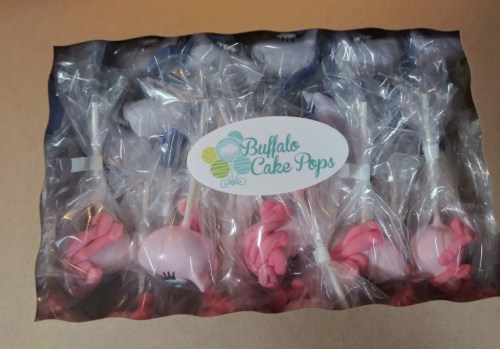 A clear bag containing cake pops with pink decorations, labeled "Buffalo Cake Pops."