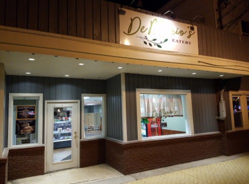 Exterior of DeMario's Eatery, featuring a welcoming entrance and illuminated sign at night.