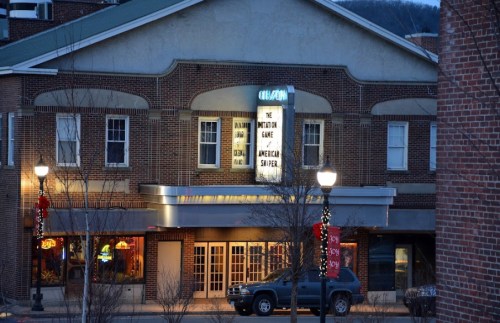 A theater marquee displays "The Imitation Game" and "American Sniper" with festive decorations outside.