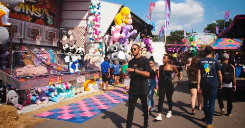 Fair-goers at the Virginia State Fair, showing colorful prizes, games, and more.