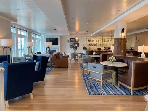 A modern lounge area with comfortable seating, a bar, and large windows letting in natural light.