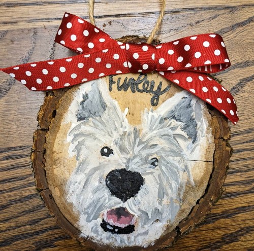 A wooden slice ornament featuring a painted dog face with the name "Funky" and a red polka dot ribbon.