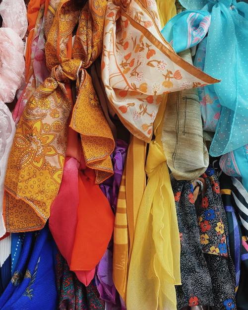 A colorful assortment of scarves in various patterns and textures, neatly arranged in a vibrant display.
