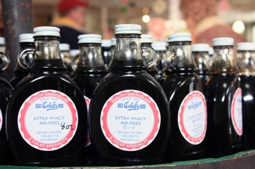 Bottles of extra fancy molasses on display, labeled with a vintage-style logo and pricing information.