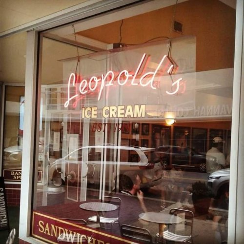 Neon sign for Leopold's Ice Cream in a storefront window, showcasing a classic ice cream parlor vibe.