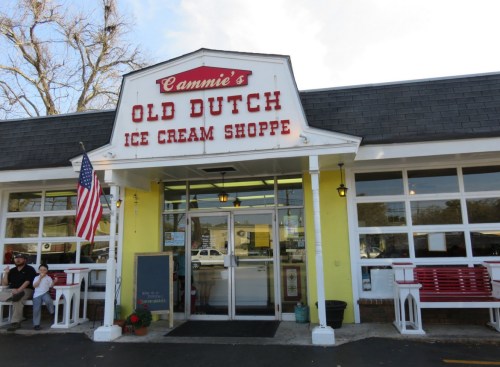Exterior of Cammie's Old Dutch Ice Cream Shoppe, featuring a bright sign, American flag, and welcoming entrance.