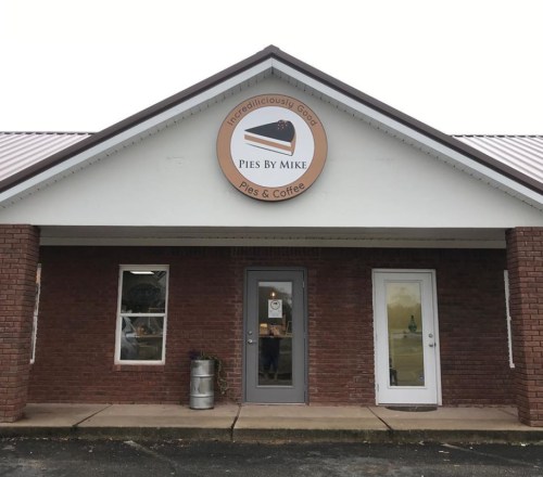 Exterior of a brick building with a sign reading "Pies By Mike" and "Incredibly Good Pies & Coffee."