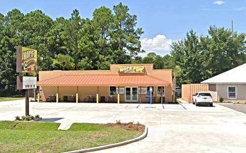 A restaurant named "Hope's" with a brown roof, outdoor seating, and a parking lot surrounded by trees.