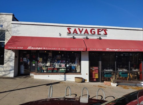 Exterior of Savage's Bakery & Deli, featuring red awnings and a display of baked goods in the windows.