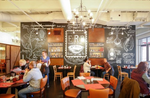 A cozy restaurant interior with chalkboard art, tables, and diners enjoying their meals.