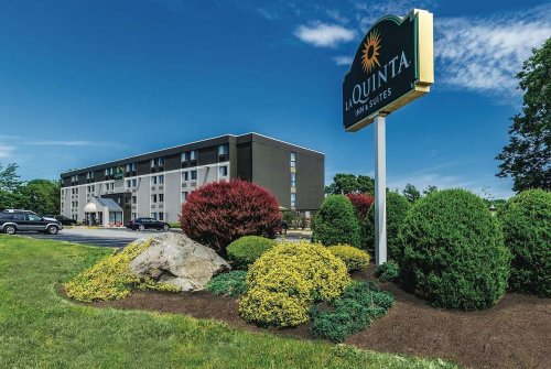 Exterior view of La Quinta Inn & Suites, featuring landscaping and a clear blue sky.