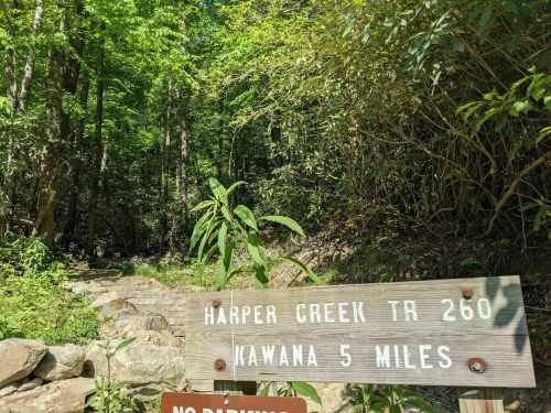A wooden sign marks the Harper Creek Trail 260, indicating Kawana is 5 miles ahead, surrounded by lush greenery.