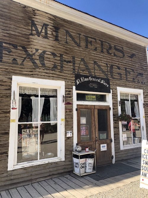 Exterior of the Miners Exchange building, featuring a wooden facade and a sign for St. Elmo General Store.