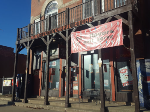 Mansfield General Store with a wooden facade and a large banner advertising soft serve ice cream.