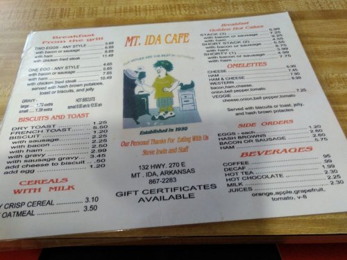 Menu from Mt. Ida Cafe featuring breakfast, sides, beverages, and prices, with a retro illustration at the top.