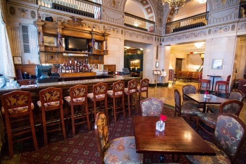 Elegant bar area in a vintage-style restaurant, featuring wooden furniture and decorative details.