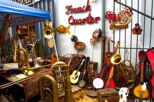 A vibrant display of musical instruments and decor in a French Quarter setting, featuring brass, string, and wooden items.