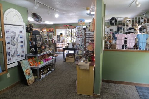Interior of a gift shop featuring various displays, souvenirs, and a checkout area. Brightly lit and inviting atmosphere.