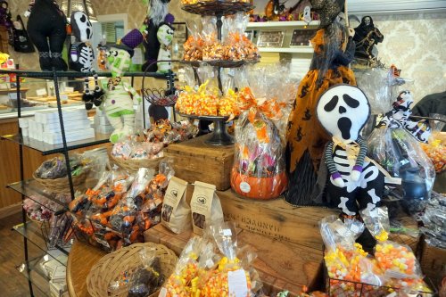 A festive display of Halloween candies and decorations, featuring skeletons, pumpkins, and colorful treats.