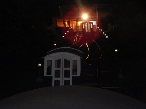 A nighttime view of a funicular railway with illuminated tracks leading up to a station.