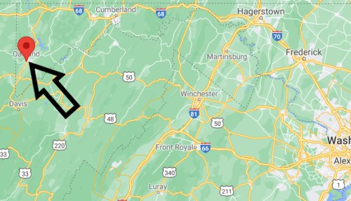 Map highlighting Oakland, Maryland, marked with a red pin and an arrow, surrounded by green mountains and roads.