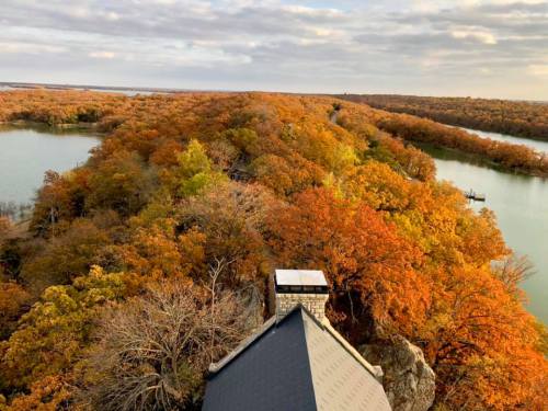 Aerial view of a vibrant autumn landscape with colorful trees surrounding a winding river.