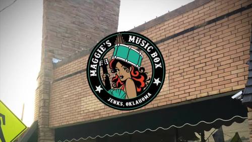Logo of Maggie's Music Box, featuring a woman with a drum, located in Jenks, Oklahoma, against a brick building backdrop.