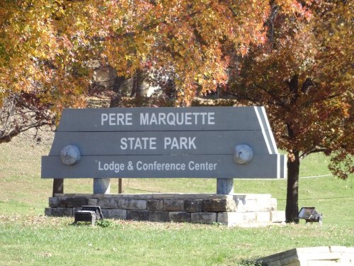 Sign for Pere Marquette State Park, featuring "Lodge & Conference Center," surrounded by colorful autumn trees.