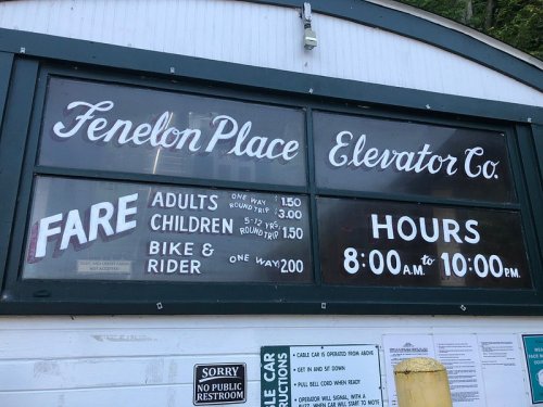 Sign for Fenelon Place Elevator Co. displaying fare prices and hours: Adults $1.50, Children $1.50, Bike & Rider $2.00. Hours: 8 AM - 10 PM.
