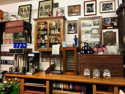 A cozy café display with vintage decor, coffee machines, and framed photos on the wall, showcasing a nostalgic atmosphere.