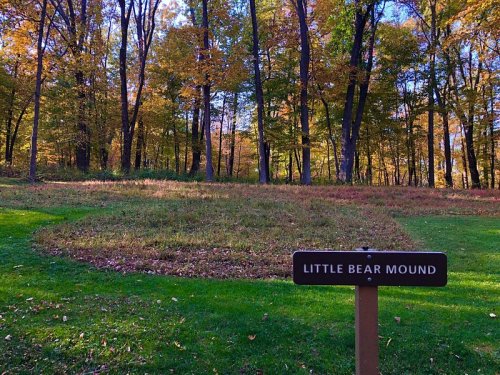 A grassy mound labeled "Little Bear Mound" surrounded by colorful autumn trees.