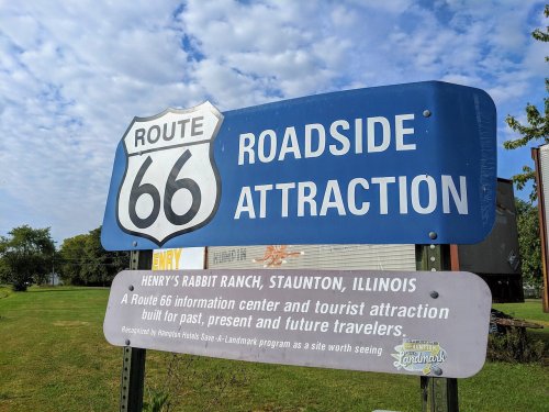 Sign for Route 66 Roadside Attraction, featuring Henry's Rabbit Ranch in Staunton, Illinois, with tourist information.