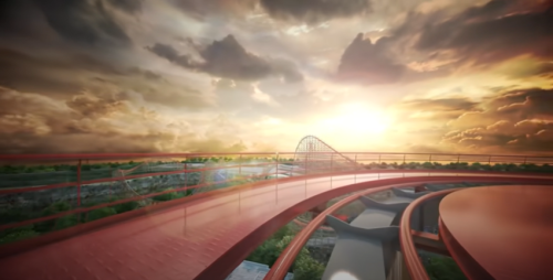 A roller coaster track curves against a dramatic sunset sky, with clouds illuminated by warm hues.