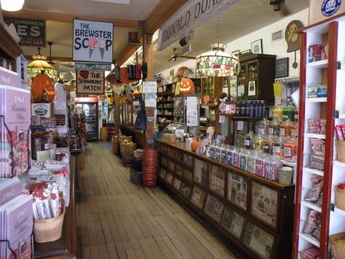 A vintage shop interior with wooden counters, shelves filled with candy, and nostalgic decor, creating a charming atmosphere.